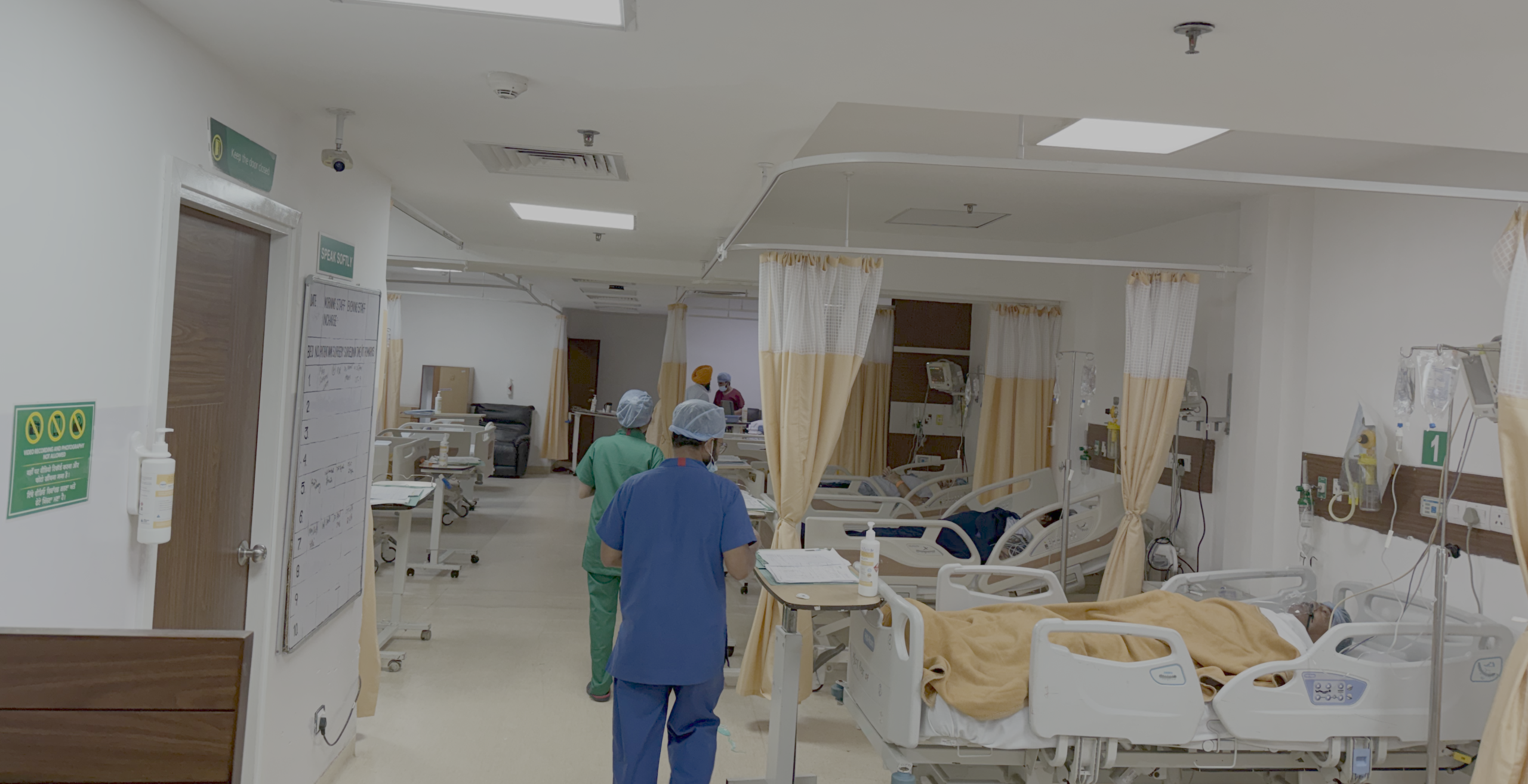 Hospital recovery area with healthcare staff caring for patients