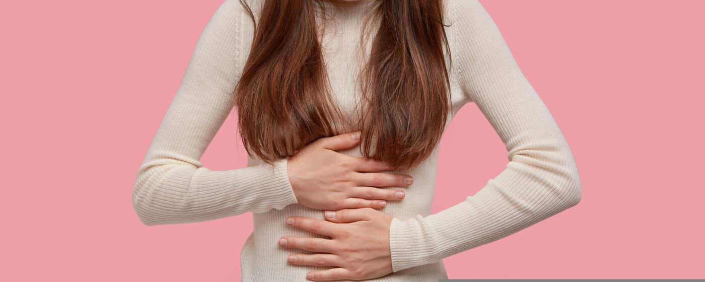 Person holding the right side of the abdomen — the location of appendix pain