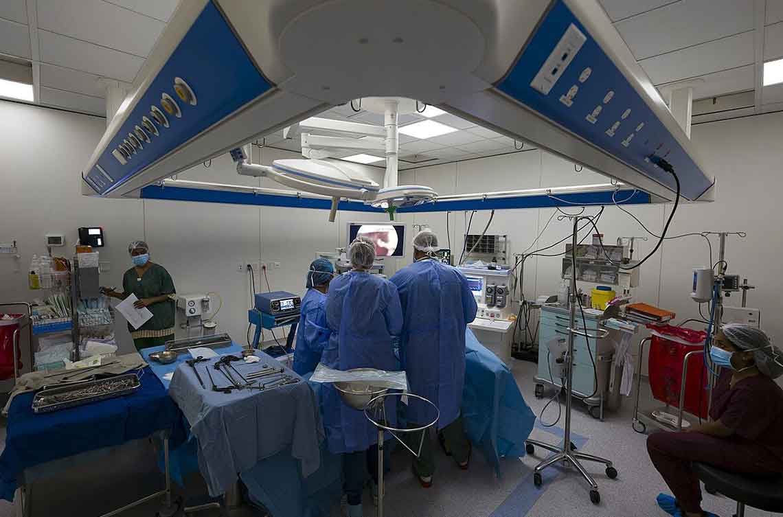 Surgical team performing laparoscopic surgery in a fully equipped operating theatre