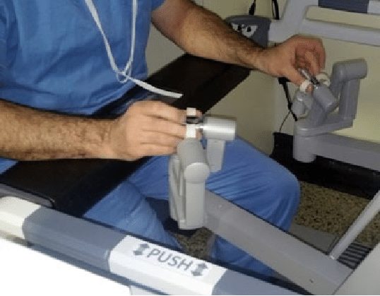 Surgeon controlling robotic arms from the Da Vinci console during minimally invasive surgery
